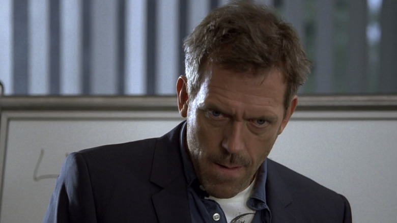 Hugh Laurie's Gregory House stands in front of a white board on House