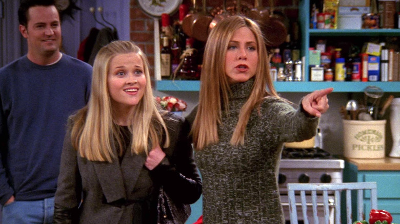 From left, Chandler Bing (Matthew Perry), Jill Green (Reese Witherspoon), and Rachel Green (Jennifer Aniston) stand in the main kitchen on "Friends"