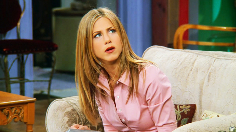 Rachel Green sentada em um sofá