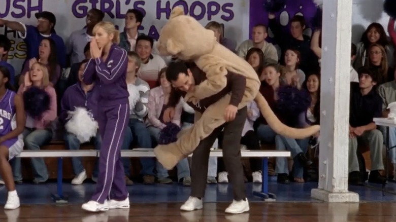 Cougar mascot jumping on back of coach at high school basketball game