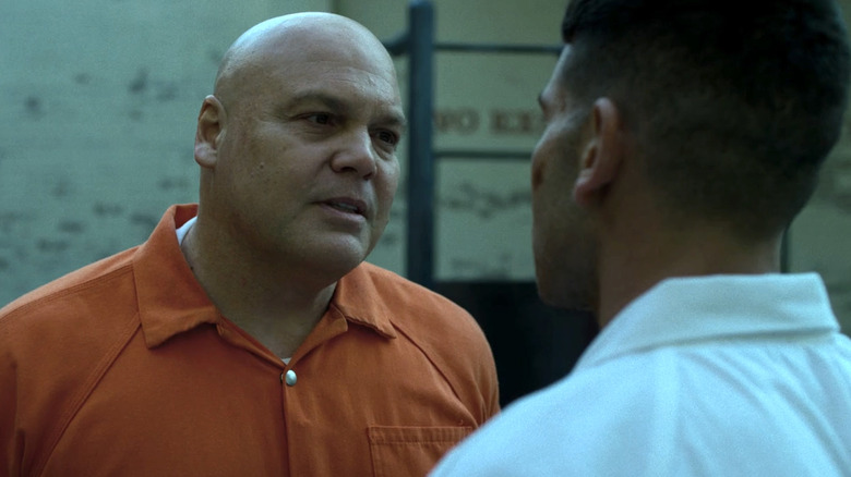 Wilson Fisk in an orange prison jumpsuit facing Frank Castle in a white shirt in a prison courtyard in Daredevil