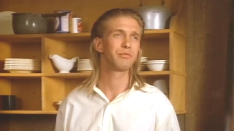 Billy Cody stood in front of wooden shelves with crockery on it in "The Young Riders."