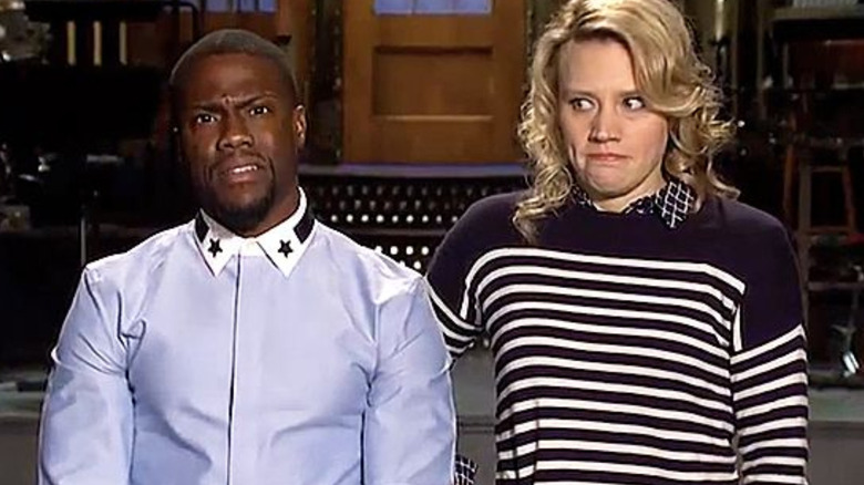 Kevin Hart delivering promo while Kate McKinnon looks concerned on Saturday Night Live