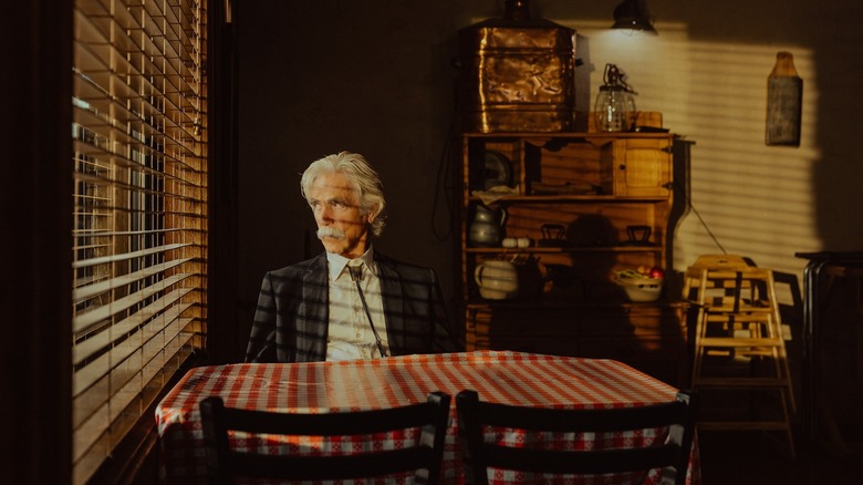 Sam Elliott as T.L. in Landman sits in a restaurant, looking out the window