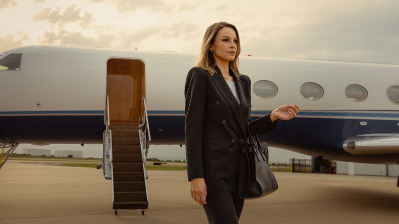 Kayla Wallace as Rebecca stands outside a private jet in Landman