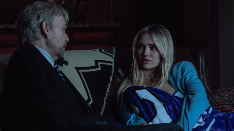 Billy Bob Thornton as Tommy and Michelle Randolph as Ainsley sit on a couch in the dark in Landman