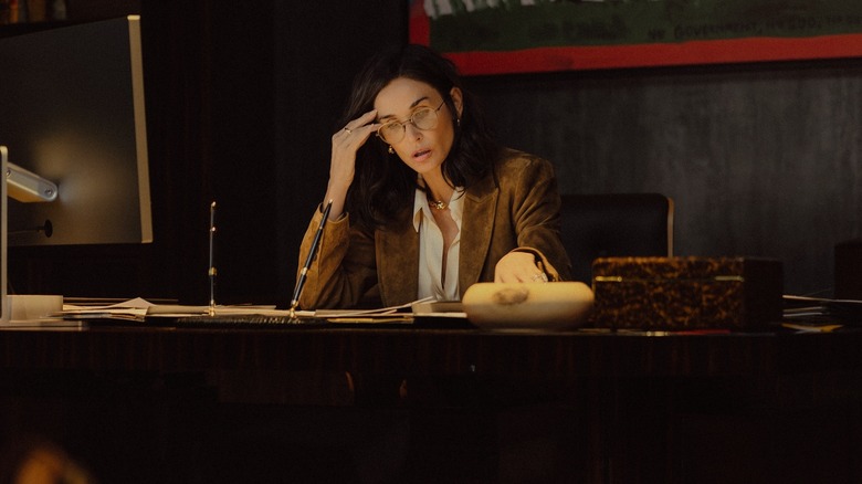 Demi Moore as Cami Miller sits at a desk and looks worried in Landman