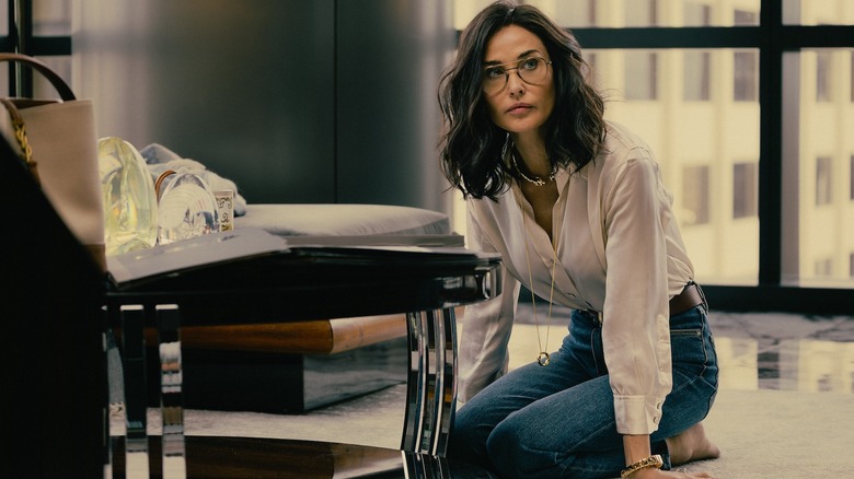 Demi Moore as Cami kneels on the ground of an office in Landman