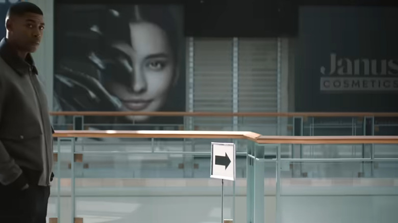 John Stewart standing in a mall nearby the Janus Cosmetics sign