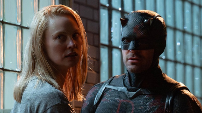Karen Page and Daredevil standing in front of a building