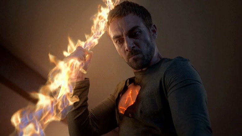 Tom Austen as Daimon Helstrom holding a flaming spear on "Helstrom"