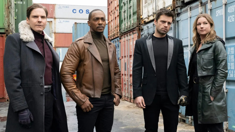 Baron Zemo, Sam Wilson, Bucky Barnes, and Sharon Carter surrounded by shipping containers in "The Falcon and the Winter Soldier"