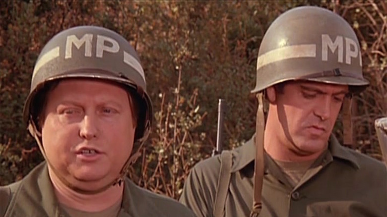 Two MPs stand together in M*A*S*H