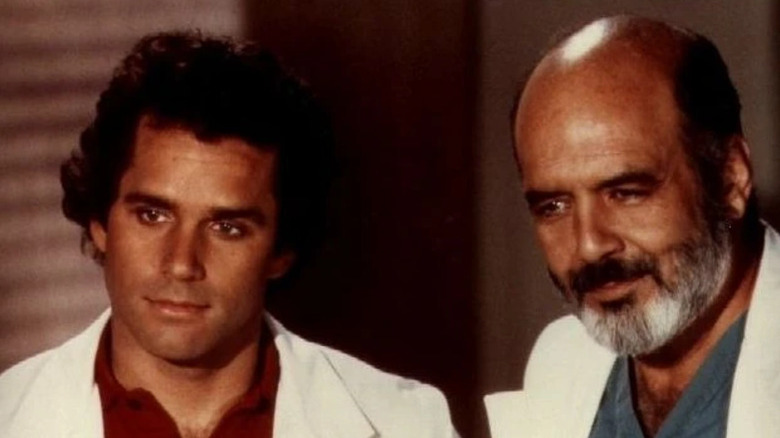 Dr. George Alonzo Gates (Gregory Harrison) and Trapper (Pernell Roberts) standing together in Trapper John, M.D.