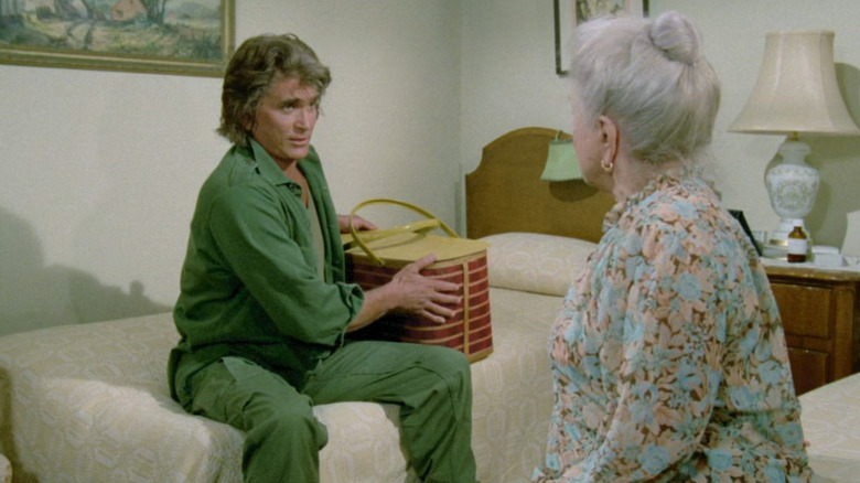 Jonathan Smith sitting on a bed across from a woman