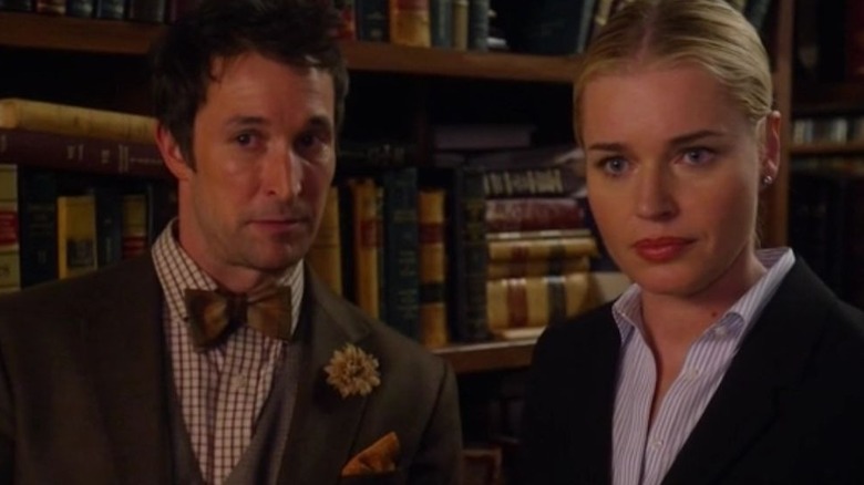 Flynn in suit and bowtie and Eve with books behind them in The Librarians