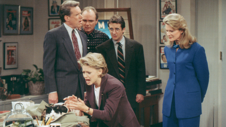 Jim Dial, Frank Fontana, Miles Silverberg, and Murphy Brown watch Corky Sherwood react to a cat on a table