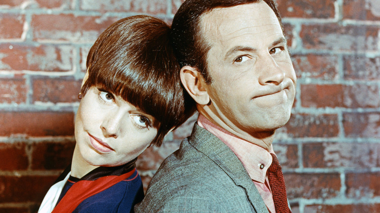A man and a woman are tied to a chair.