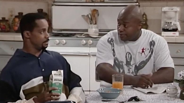 Joey and Charles Emerson looking at one another while sitting at the breakfast table