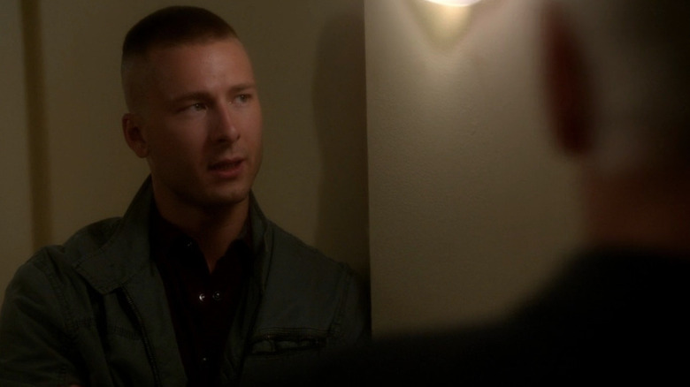 Glen Powell with buzzed head standing across from Gibbs (Mark Harmon) in NCIS