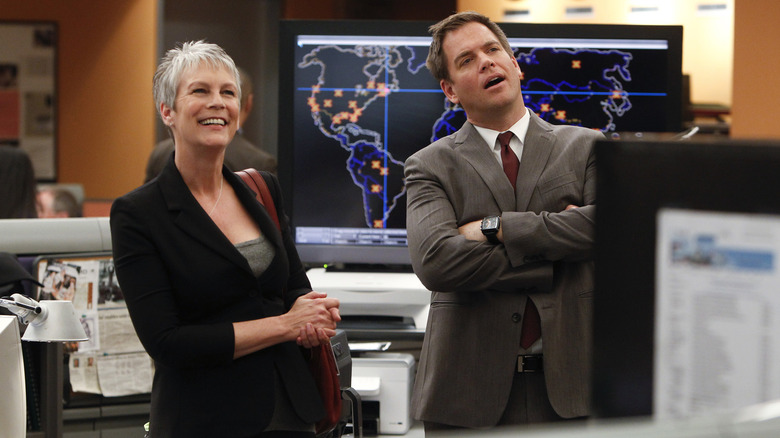 Jamie Lee Curtis smiling in NCIS bullpen next to Michael Weatherly as Tony in NCIS