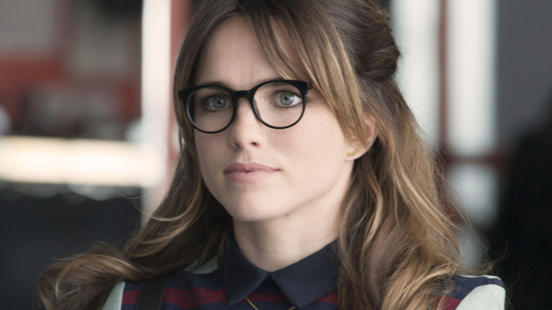 Jacqueline Byers as overbearing groupie Natalie Shayne, dressed smartly and wearing glasses, on Showtime's Roadies.