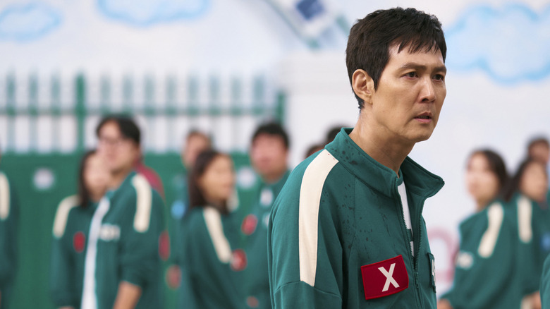 Lee Jung-jae as Seong Gi-hun dressed in a green jumpsuit and in "Squid Game" Season 2.