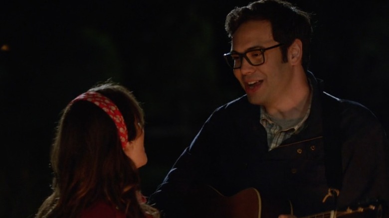 Robby and Jess sing by a camp fire