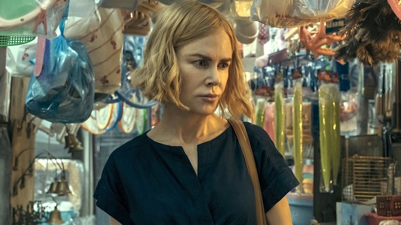Margaret standing in a cluttered store in Expats