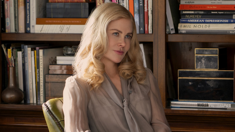 Greer sitting at her desk smirking at someone on The Perfect Couple