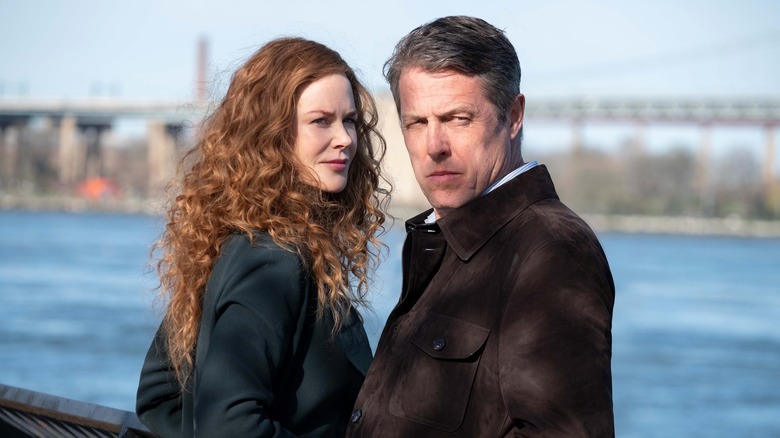 Grace (Nicole Kidman) and Jonathan (Hugh Grant) by the water looking over their shoulders on The Undoing