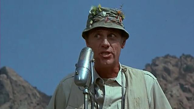 Henry Blake speaking into a microphone outside on M*A*S*H