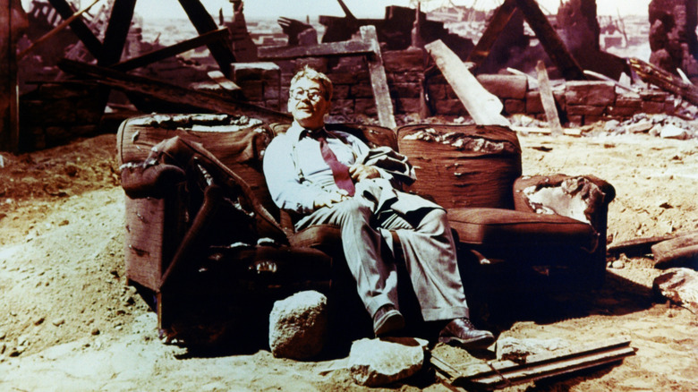 Burgess Meredith as Henry Bemis in the "Twilight Zone" episode "Time Enough at Last" sitting on a ruined couch