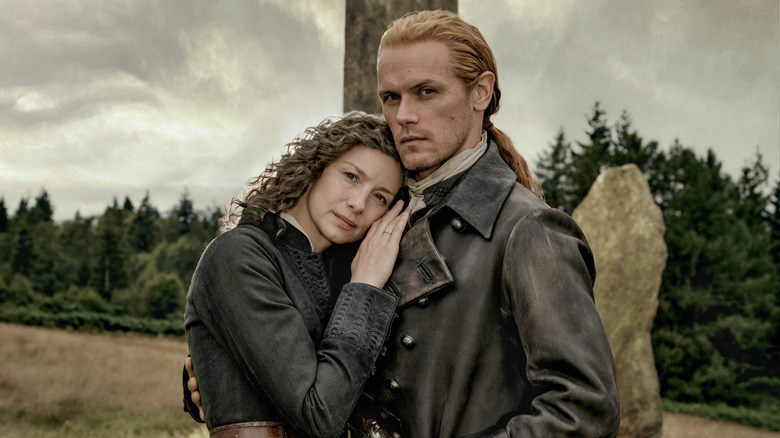 Catriona Balfe as Claire and Sam Heughan as Jamie in leather period attire in "Outlander" Season 8.