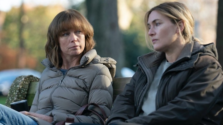 Lori Ross and Mare Sheehan sitting on a bench in Mare of Easttown