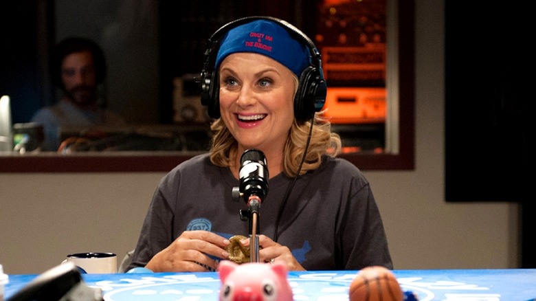 Amy Poehler as Leslie Knope in a T-shirt and backwards cap on the radio in Parks and Recreation