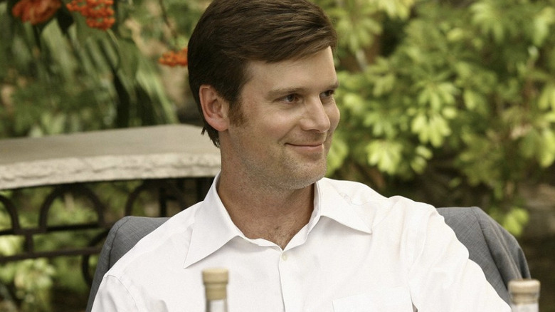 Nick George in white shirt smiling at outdoor wedding reception