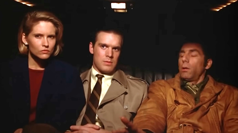 Eva, Tim, and Kramer in the back seat of a limo at night in Seinfeld.
