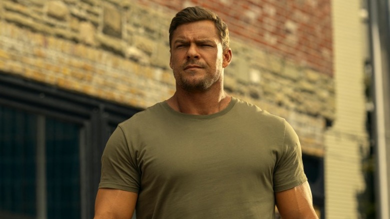 Jack Reacher looking serious while walking down the street