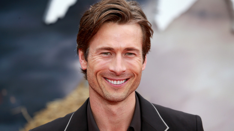 Glen Powell wearing a black suit at the "Twisters" European Premiere at Cineworld Leicester Square in London, England.