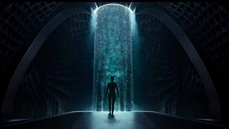 Mother standing in front of a massive computer known as The Trust