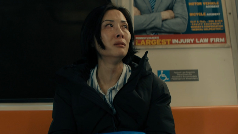 Anna Merrick on a subway train, looking to the side