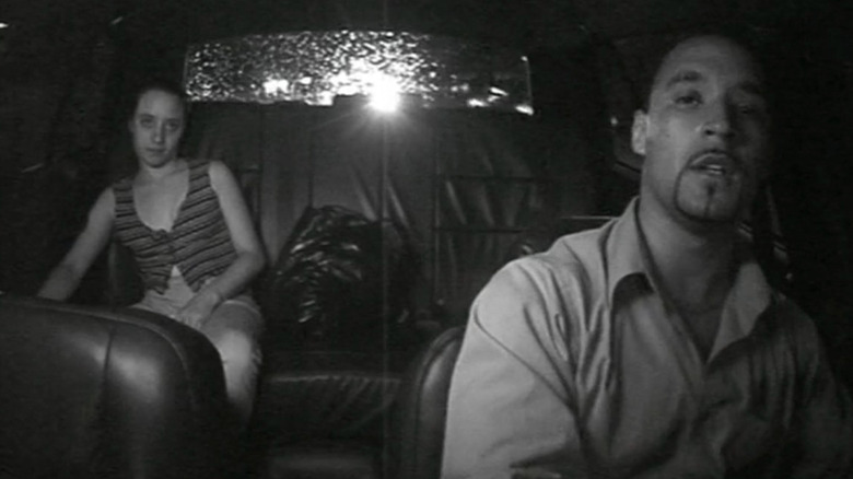Taxi driver talking to woman in the back seat of cab in Taxicab Confessions