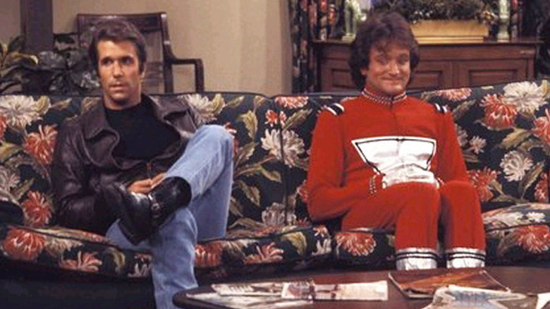 The Fonz (Henry Winkler) and Mork from Ork (Robin Williams) sit together on a couch.