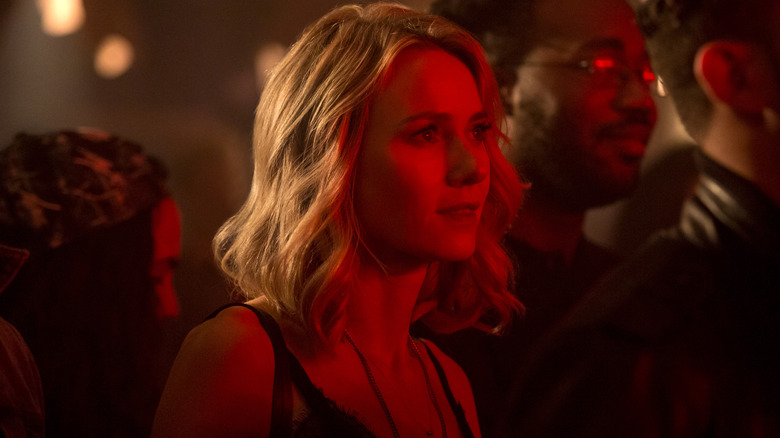 Naomi Watts as Jean facing a bright red light and smiling in Gypsy