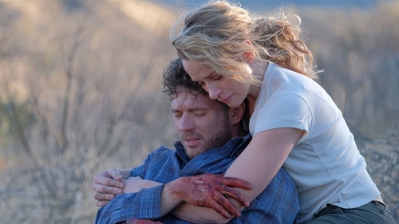 Bob Lee Swagger (Ryan Phillippe) crying with blood on his hands while Julie Swagger (Shantel VanSanten) embraces him in a scene from "Shooter."