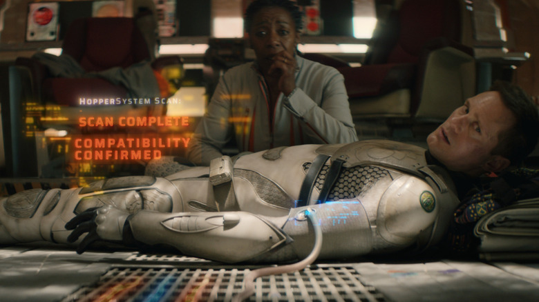 Mensah scanning Murderbot on table