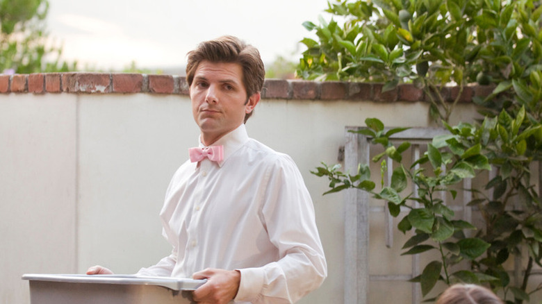 Henry Pollard carries a plastic bin while wearing his catering uniform in Party Down