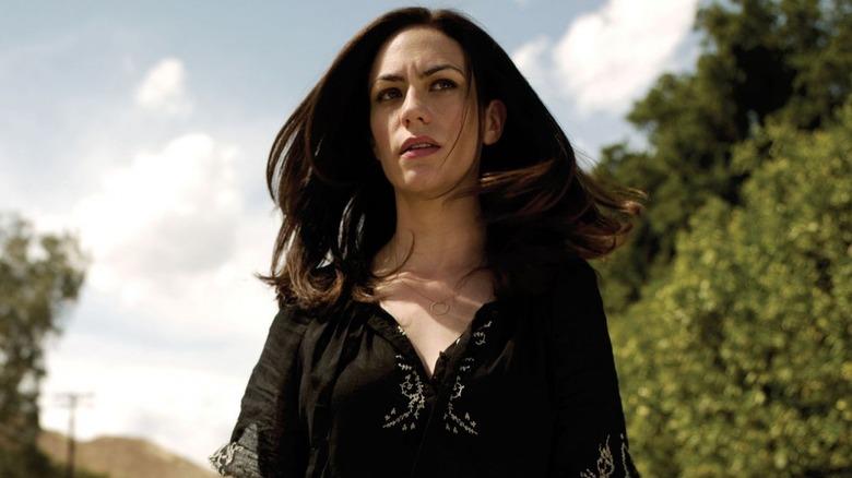 Maggie Siff as Tara Knowles-Teller, walking near trees in Sons of Anarchy.