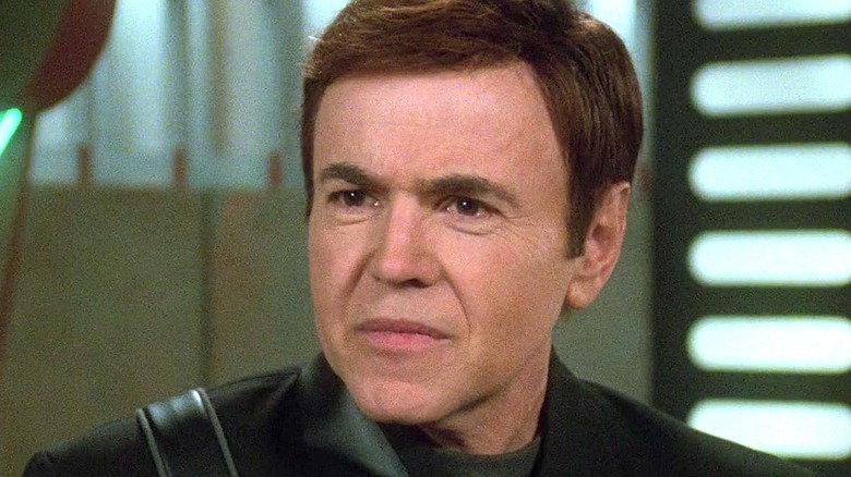 Alfred Bester looking serious while wearing a black uniform in Babylon 5 Season 5